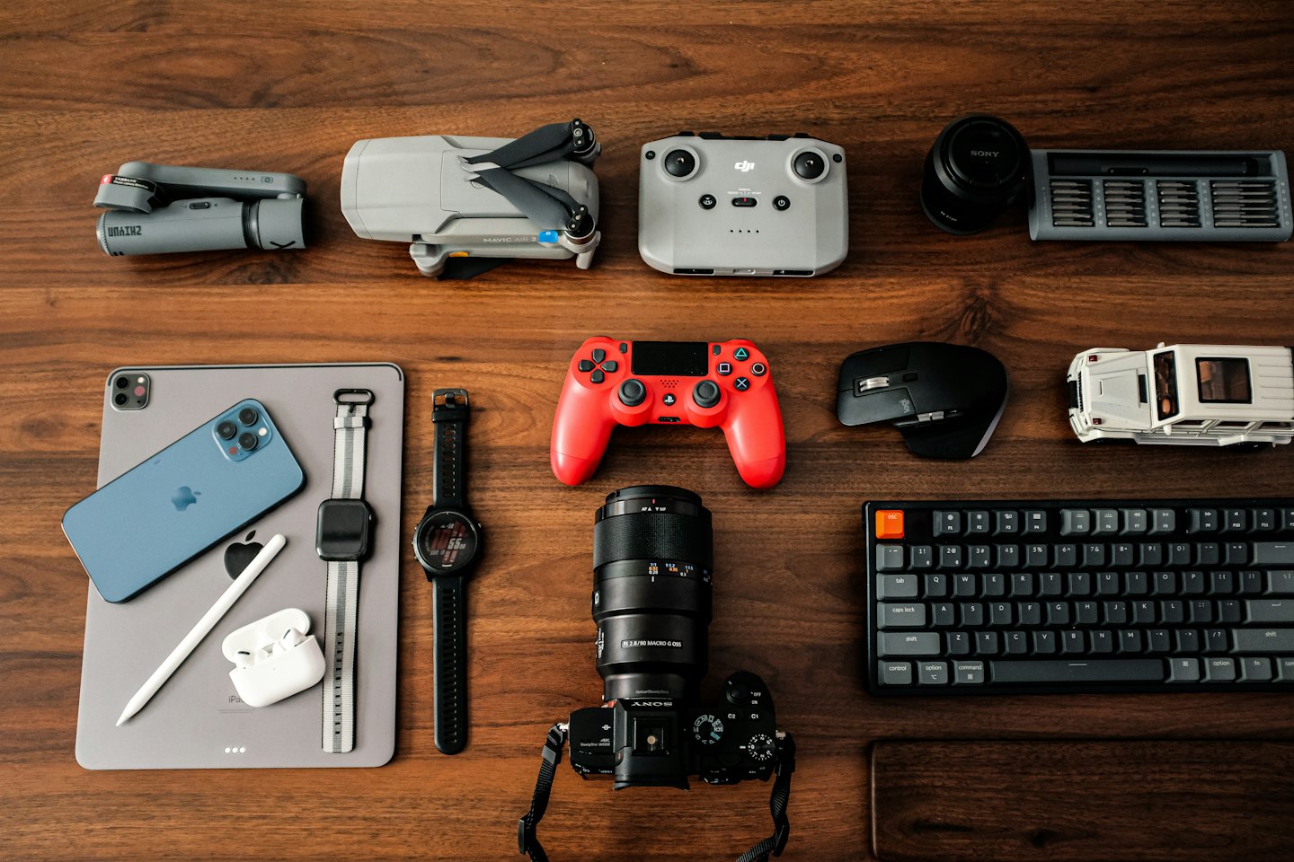 Assorted electronic gadgets arranged neatly on a wooden desk.