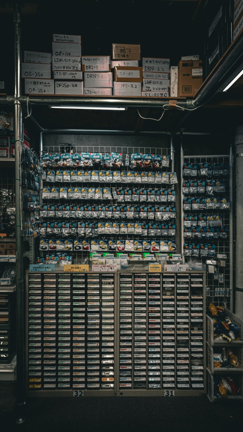 Small electronic parts organized in plastic bags on a grid wall.